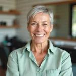 Femme de 60 ans avec une coupe courte pixie cut adaptée à un visage rond, assise dans un salon de coiffure moderne