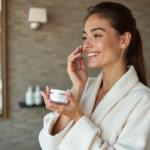 Jeune femme appliquant une creme visage dans une salle de bain moderne